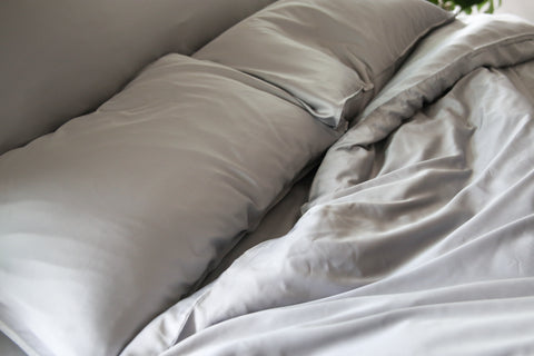 An image of a bed with white sheets and pillows made from Pillowtex Copper Infused Bamboo fibers.