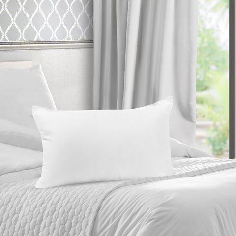 A white Pillowtex Pillow Insert | Polyester sits on top of a bed.