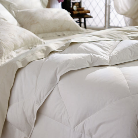 A bed with a Restful Nights All Natural Down Comforter | All Season and hypoallergenic pillows.