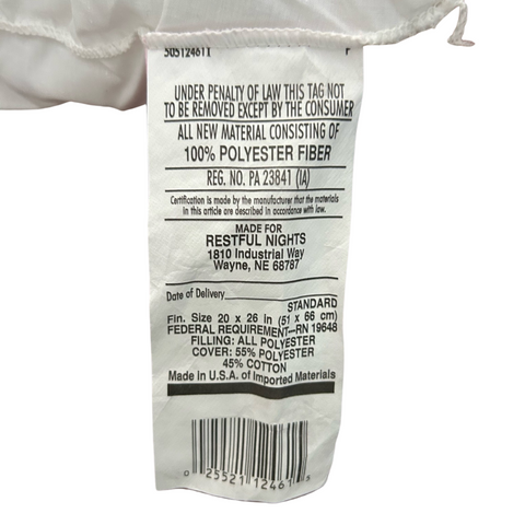 A close-up of a white clothing tag showing washing and material details, such as "100% polyester" and "made in USA" for a Restful Nights® Royal Loft® Polyester Pillow. The tag also includes barcodes and branding from Restful Nights.