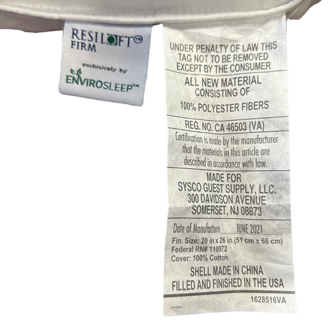 Close-up of a white law label on an eco-friendly pillow. The top part of the tag shows the brand name "Manchester Mills" with "Exclusively by Envirosleep". Below