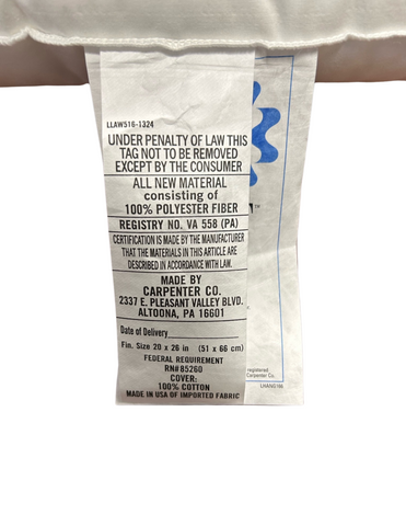 A care label attached to a white garment provides laundering instructions, material composition (Carpenter Co. Debut Supreme Cluster Fiber Pillow), and manufacturer details—Carpenter, including a registry number and QR code for tracing compliance.