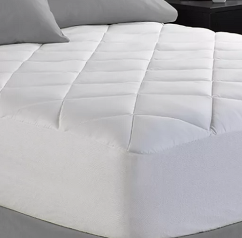 A Spring Air Illuna Plush Comfort mattress pad, neatly arranged on a bed, featuring a quilted design that offers additional cushioning for comfort and improved sleep quality.