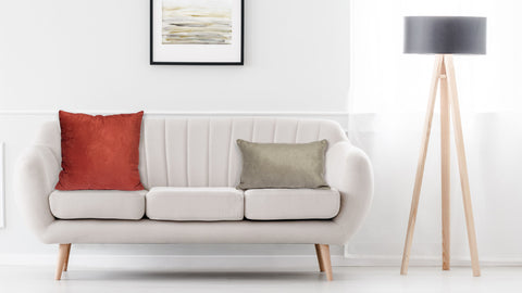 A white couch with a Pillowtex Faux Suede Decorative Throw Pillow in front of a white wall.