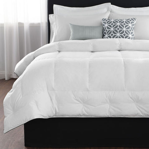 A bed with a white Restful Nights Down Alternative Comforter and pillows.