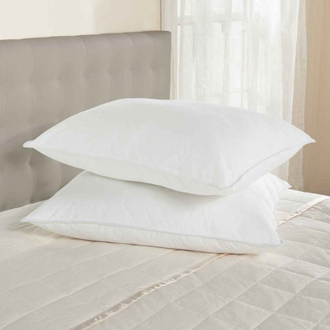 Two Encompass Group 50/50 White Duck Feather and Down Pillows on top of a bed.