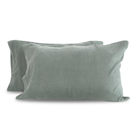 Two Delilah Home Hemp Pillowcases in soft sage green with a linen texture, suggesting a cozy, sustainable, and elegant home decor theme, isolated on a white background.