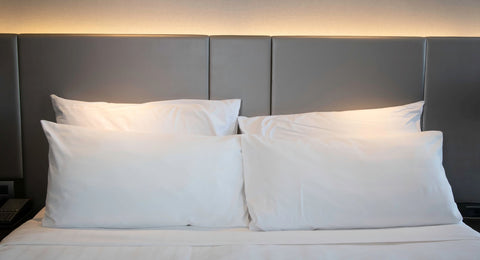 Two Pillowtex pillows on a hotel bed with a cotton polyester blend fabric and 300 thread count.