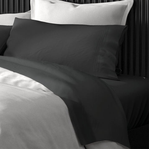 A black and white bed with PureCare Premium Bamboo Sheet Sets and white pillows.