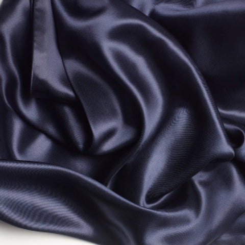 A close up of a PureCare Pure Silk Pillowcase in dark blue, perfect for hair care.