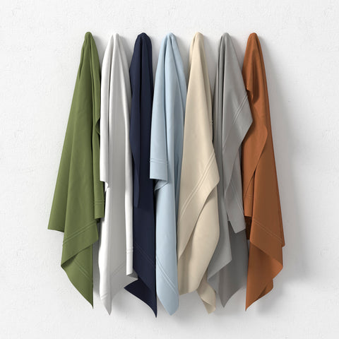 Five PureCare Premium Soft Touch TENCEL™ Modal Sheet Sets in different colors hang on the wall.