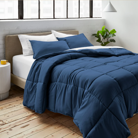 A Pillowtex bed with a blue Pillowtex Essential Bedding Package comforter and pillows designed to help you dream in color.