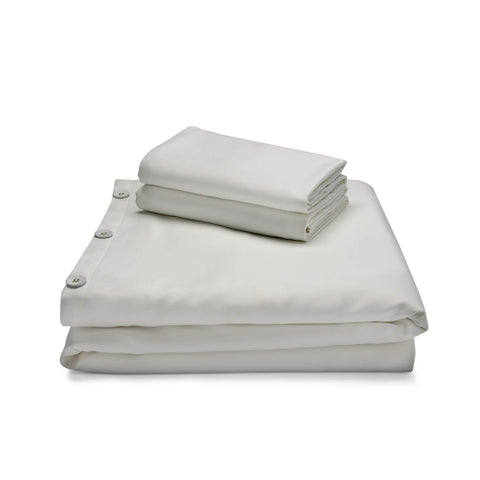A Malouf Bamboo Duvet Set of hypoallergenic white sheets on a white surface.