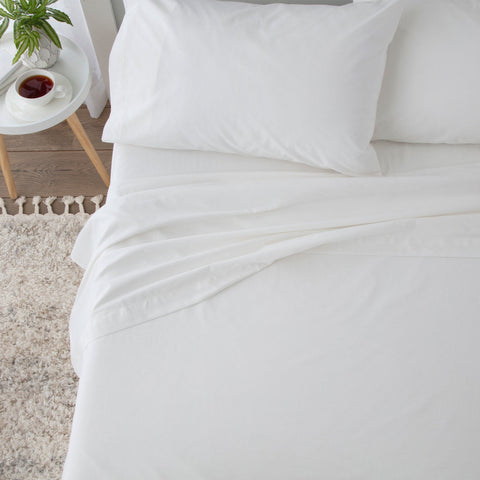 A white bed adorned with soft pillows and a Martex Grand Patrician Flat Sheet | 310 TC.