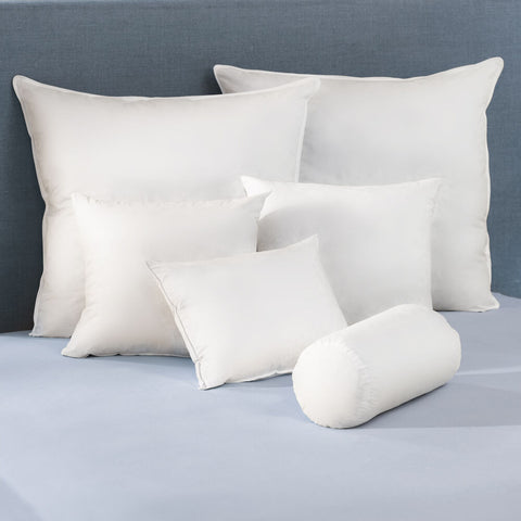Four Keeco Pacific Coast Feather Pillow Inserts | Euro Square 26" rest on top of a bed.
