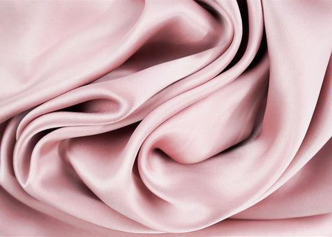 A close up of a pink satin fabric, perfect for skin care or Pillowtex 100% Mulberry Silk Pillowcase with Zipper Enclosure, 16 Momme.