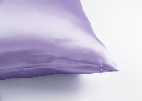 A silky purple Pillowtex 100% Mulberry Silk pillowcase with a smooth texture and a visible zipper on a light background, accentuating a sense of softness and luxury.