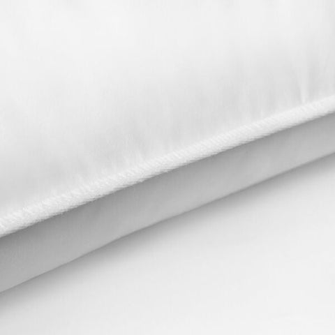 A close up of a white Pacific Coast Feather Company Double Touch of Down Pillow on a white surface.