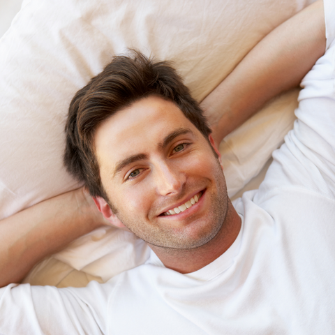 A man in a white shirt is comfortably sleeping on a Pillowtex White Duck Down & Feather Pillow | 75% Feather/25% Down.