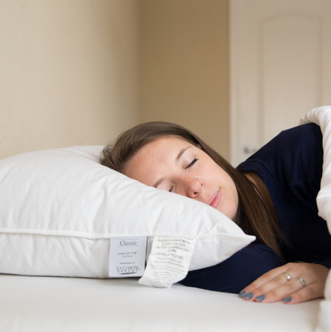 A woman sleeping on a Down Dreams Classic Soft Pillow, featured at many hotels by Manchester Mills, filled with feather and down.