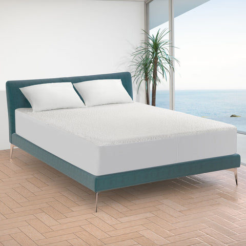 A bed with a view of the ocean, now protected by a Protect-A-Bed Snow Mattress Protector made from Nordic Chill fabric.