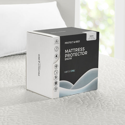 A box of a Protect-A-Bed Snow Mattress Protector from Protect-A-Bed on a bed.