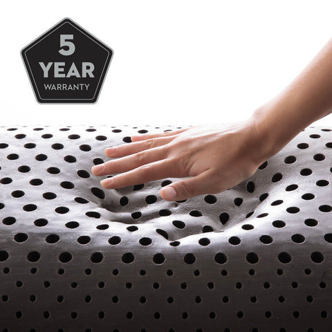 A person is touching a Malouf Shoulder Zoned Dough + Bamboo Charcoal pillow with a 5 year warranty from Malouf.