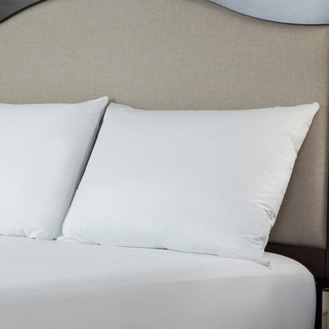 Two Protect-A-Bed Basic Waterproof Pillow Protectors on a bed with a headboard.