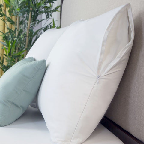 A white pillow on a bed with a Protect-A-Bed Basic Waterproof Pillow Protector.