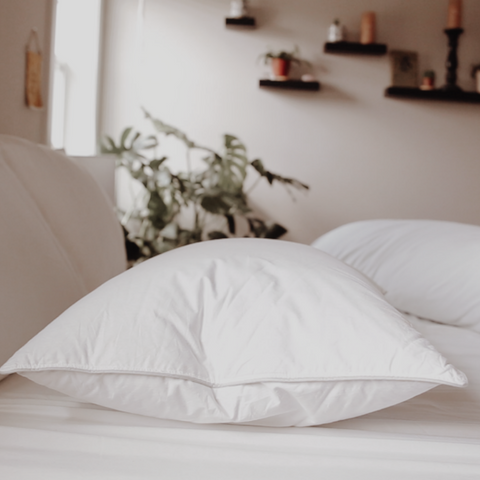 A Manchester Mills Down Dreams Classic Firm Pillow sits on the bed, perfect for side sleepers.