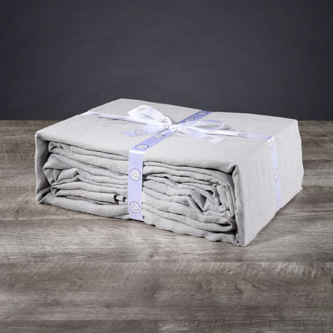 A sustainable Delilah Home Hemp Sheet Set with a blue ribbon tied around it.