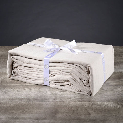 A stack of folded towels on a sustainable wooden table.