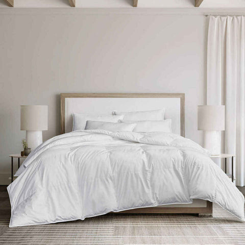 A DOWNLITE White Goose Down Comforter | Medium Weight, on a bed in a bedroom.