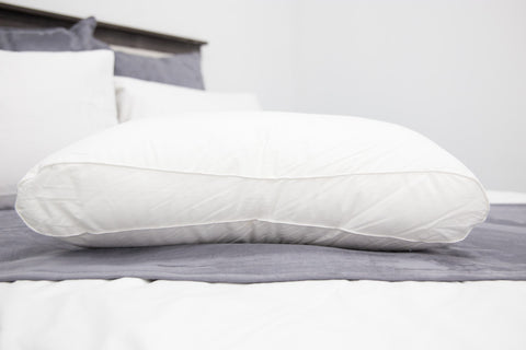 An Holiday Inn® Infinity Pillow | Extra-Firm Support pillow on a bed.