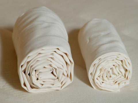 Two rolls of white Holy Lamb Organics Organic Cotton cloth sitting on top of each other.