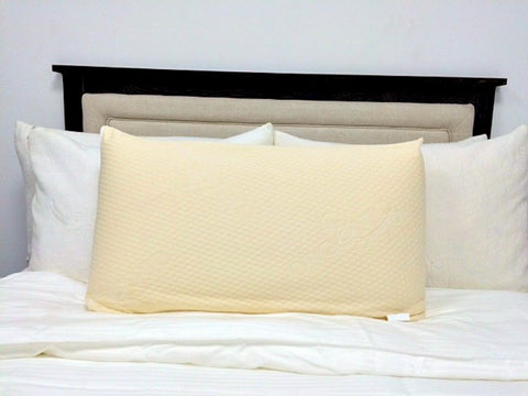 A white Latex International® Rejuvenite Natural Low Profile pillow on top of a comfort bed.