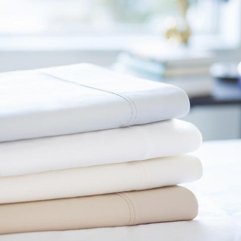 A stack of Malouf 600 TC Cotton Blend Pillowcase set, by Malouf, featuring a TC Cotton Blend for a breathable feel.