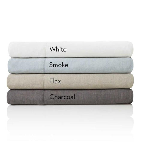 A stack of Malouf Woven French Linen Sheet Set with the words white smoke, flannel, and charcoal.