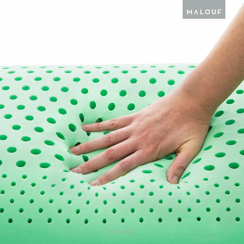 A person's hand is holding a Malouf Zoned Dough Peppermint Pillow.