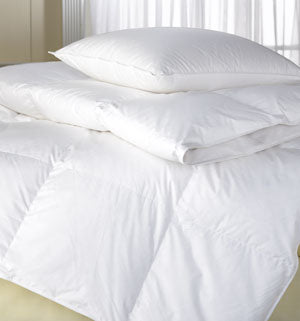 A Restful Nights Down Alternative Comforter and pillows on top of a bed.