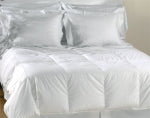 A white comforter on a bed made of Natural Living Ingeo blends luxury with comfort.
