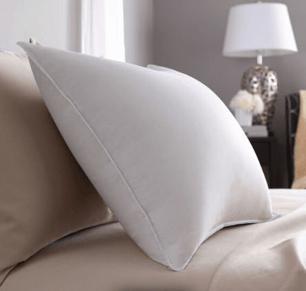 A Pacific Coast Feather Pillow from Pacific Coast Feather Company sits atop a bed, providing support.