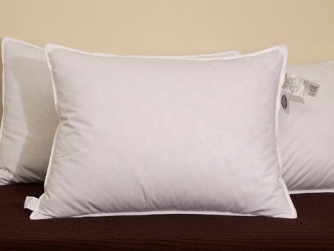 Two Pacific Coast Feather Tria Down & Feather Pillows by Pacific Coast Feather Company on a bed with tags on them.