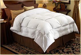 A bed with a Pacific Coast Feather Company White Goose Down Stratus Down Comforter and brown pillows.