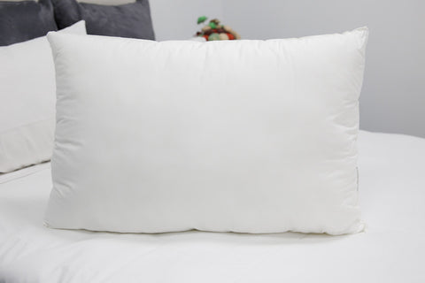 A Pillowtex White Duck Down & Feather Pillow filled with 95% Feathers/5% Down on top of a bed.