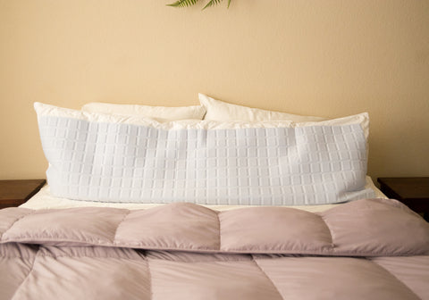 A bed with a Pillowtex Body Pillow Cover | Cooling Gel made of 100% cotton on top of it.