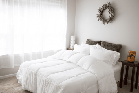 A white Pillowtex Essential Bedding Package All Season Comforter on a bed.
