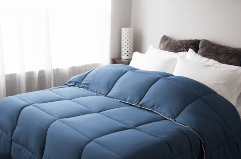 A Pillowtex Essential Bedding Package with All Season Comforter and Matching Pillows on a bed in a bedroom.