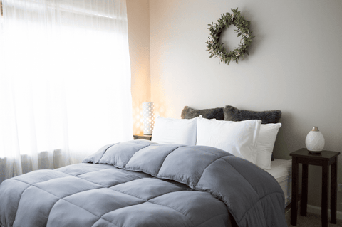 A Pillowtex Essential Bedding Package with a grey comforter and a wreath on it for all-season comfort.