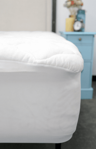 A close up of a Pillowtex Bamboo Mattress Topper with a white cover and polyester fiber.